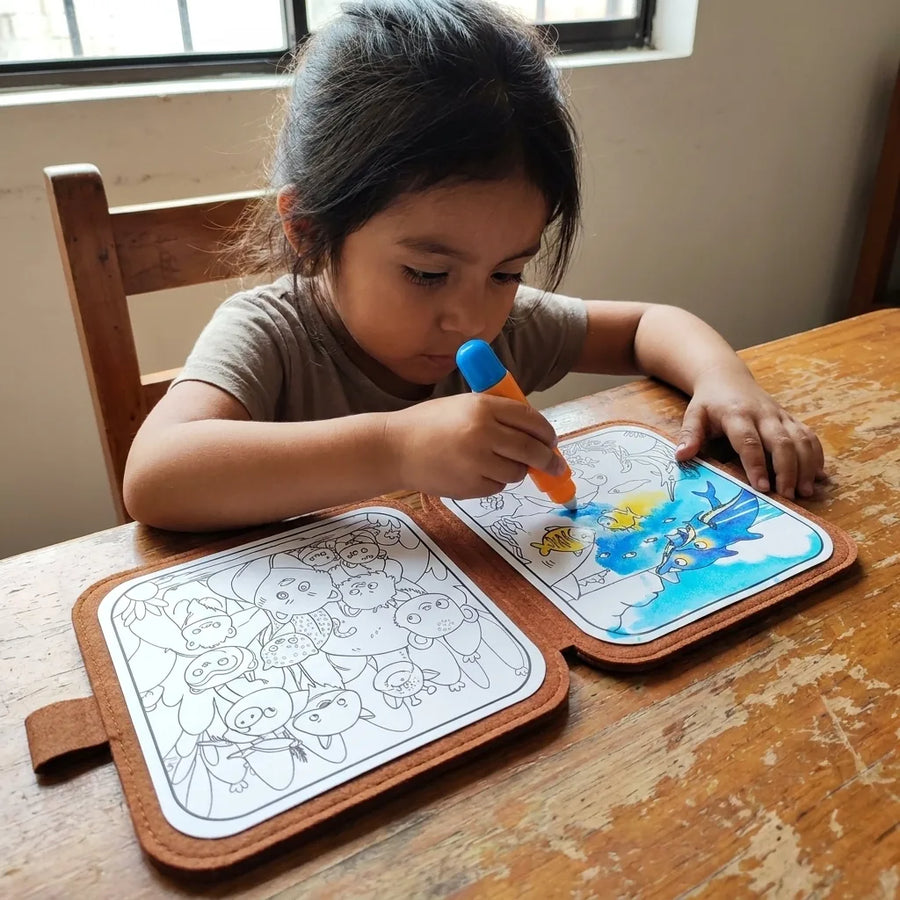Niña pintando con el pincel de agua